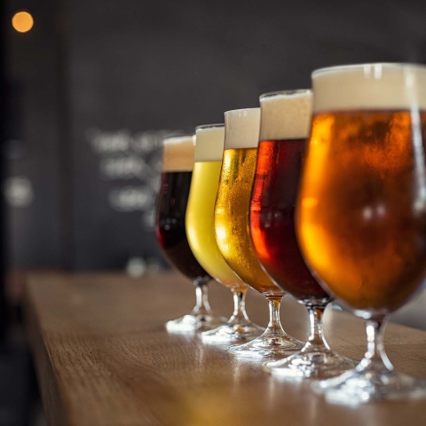 Glasses with different sorts of craft beer on wooden bar