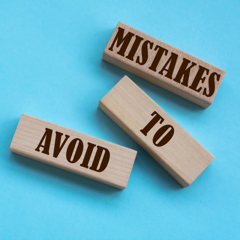 Mistakes to Avoid words written on wooden blocks on a blue background