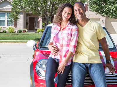 Couple leaning against the front of a car