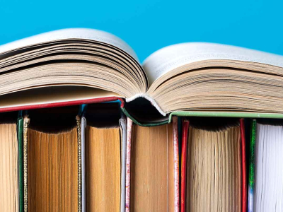 A row of books with an open book laying on top