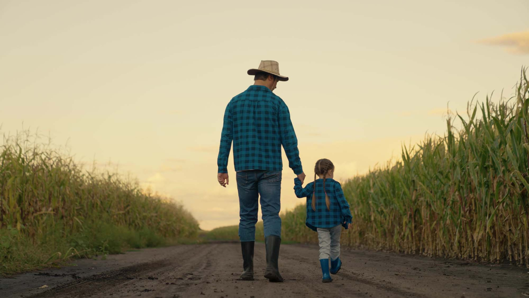 Dad and daughter look at their corn field